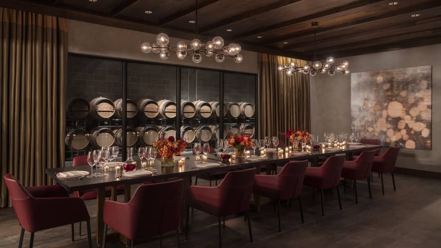 Private dining room, long table with 14 chairs, wooden ceiling, wine barrels