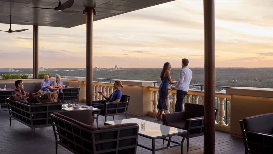 People lounge on Capa Bar terrace under roof at sunset