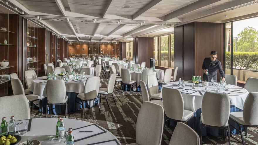 Hotel staff sets round banquet dining tables in event room