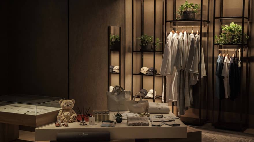 Spa boutique with shelf of white robes and shirts hanging along with other retail items