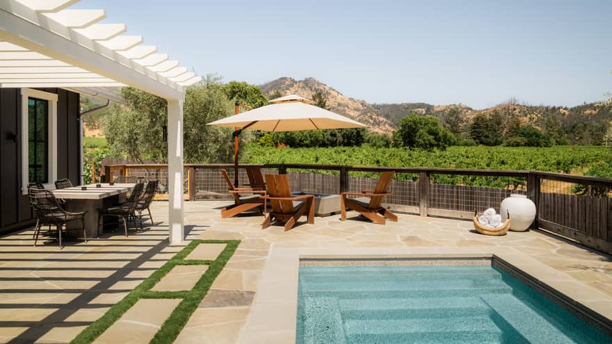 Residence backyard featuring pool, table with shade umbrella and dining table