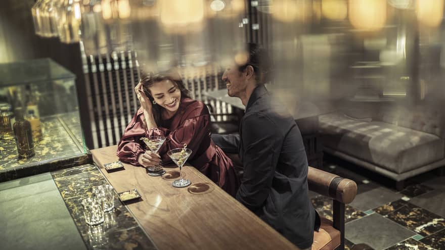 Laughing couple enjoys martinis at The Lounge 