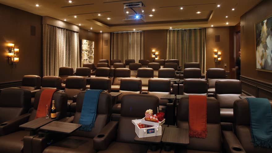 A small movie theatre with a box of snacks in the front row.