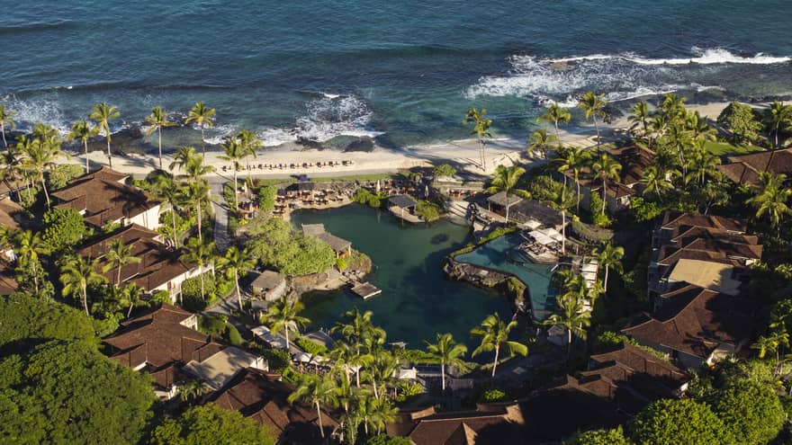 Aerial view of a pond-like pool at a tropical resort by the beach