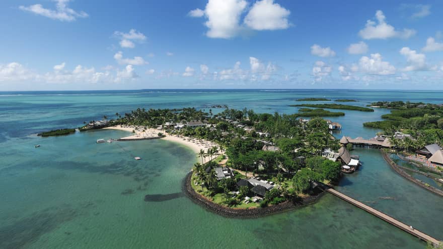 Aerial view of the lush island of Mauritius surrounded by blue-green waters and under blue skies