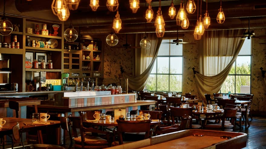 Proof restaurant with shuffleboard table and hanging lights, at Four Seasons Resort Scottsdale