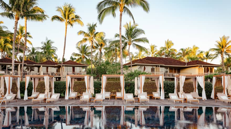 Outdoor luxury resort pool with cabanas and ocean view at Four Seasons Resort Hualalai, Hawaii