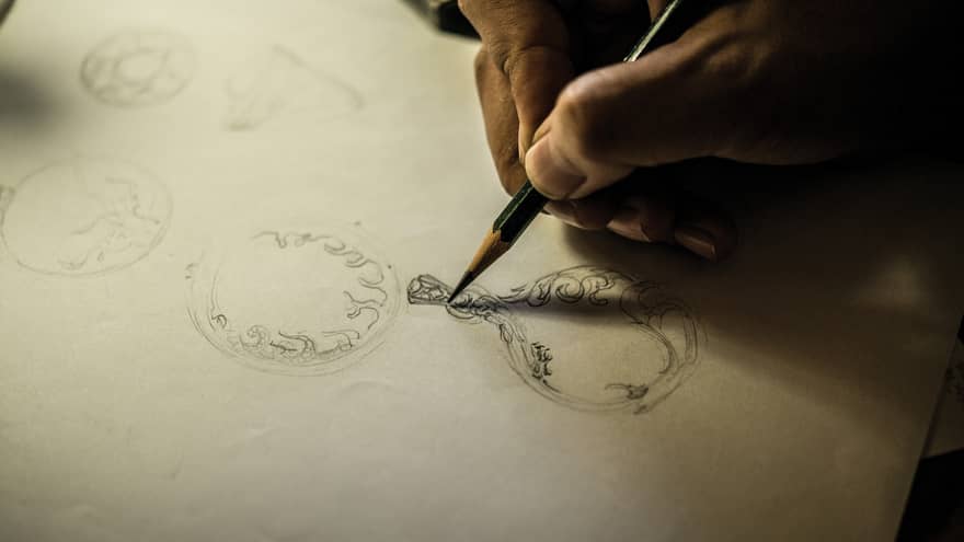 Man's hand sketching jewellery designs