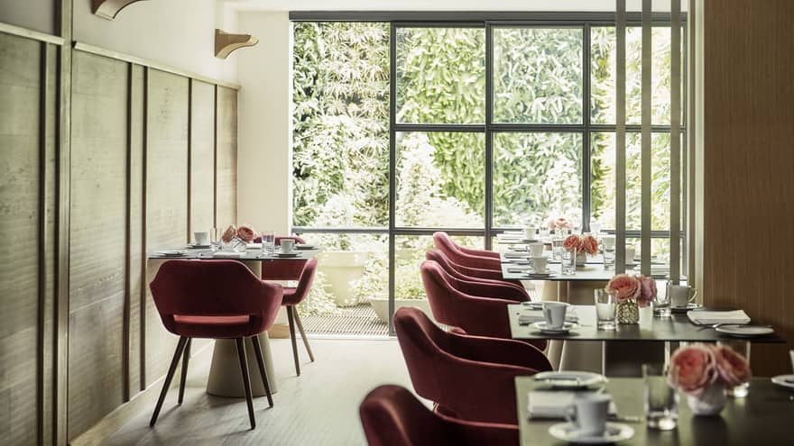 Biblioteca red retro-style velvet dining chairs at table, sunny room with floor-to-ceiling window