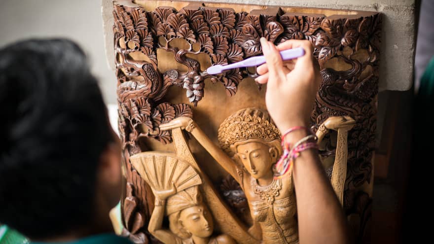 A Four Seasons staff cleaning an artifact at the CEO Circle event at Four Seasons Bali