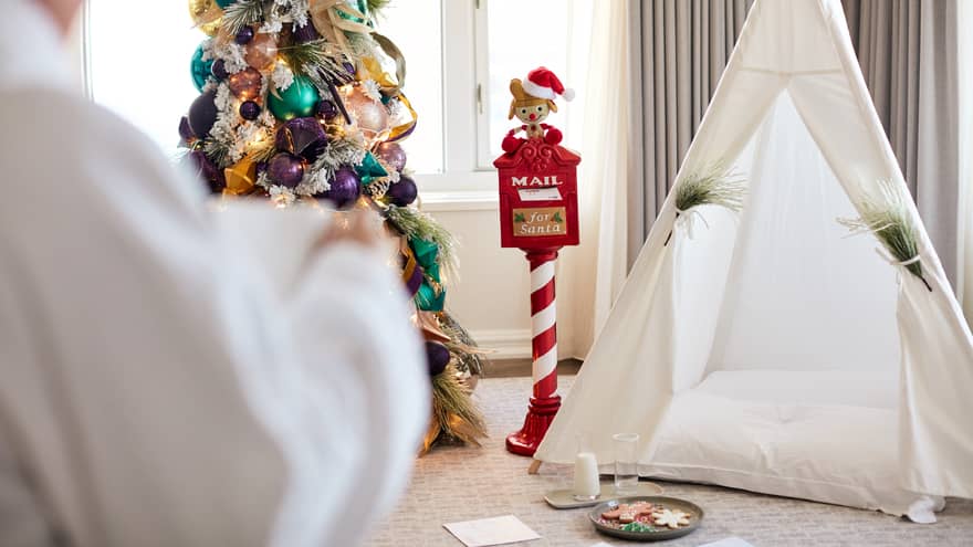 A tent next to a small Christmas tree.