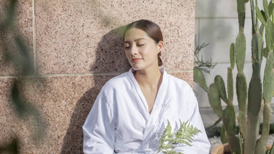 A woman in a spa robe enjoying the afterglow of a massage at the Four Seasons Hong Kong Spa.