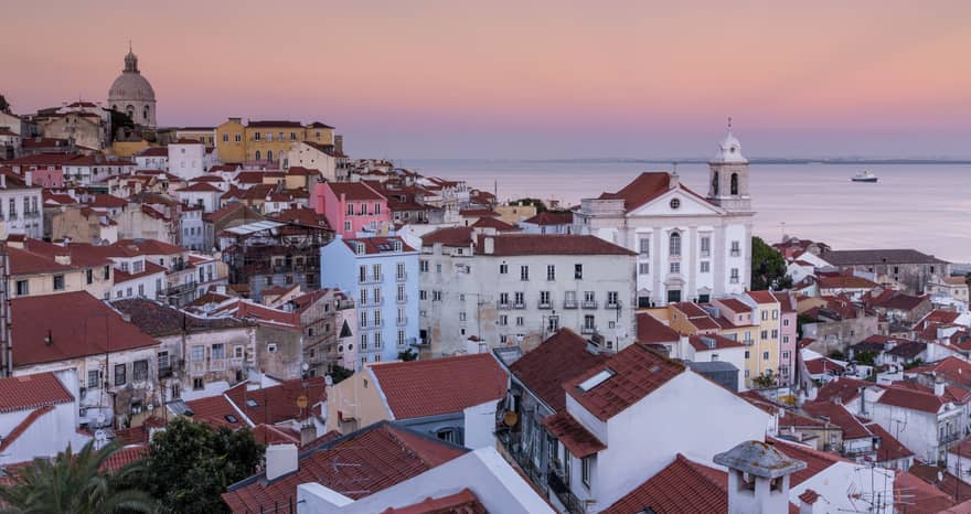 Aerial view of Lisbon traditional buildings with white houses, apartment buildings with brown roofs, white church
