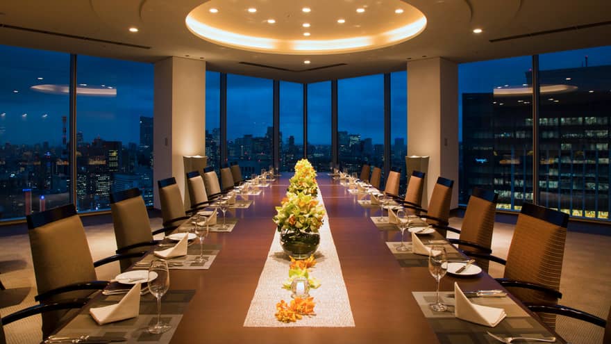 Long Executive Dining Room table under dome ceiling with lights, city lights through window