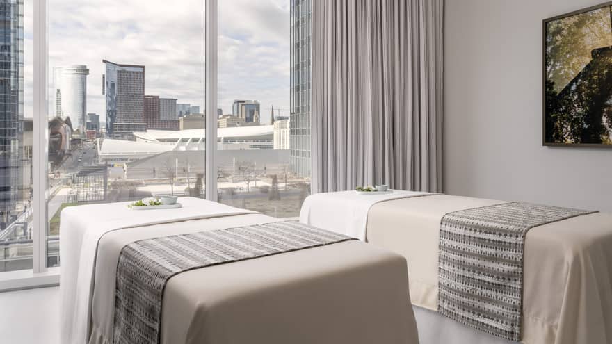 Two spa beds in a room with a large window.