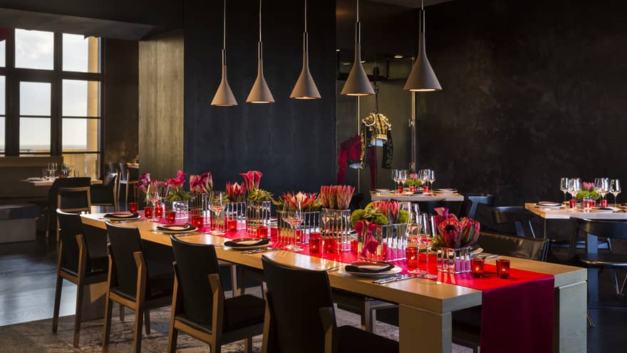 Long table with red runner under row of lamps in San Sebastian private dining room