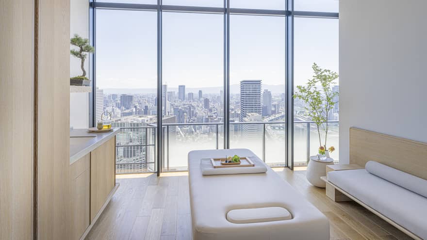 Spa treatment room with light wood cabinets and wall of windows, at Four Seasons Hotel Osaka