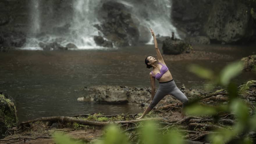 Woman practises yoga at the Ngardmau waterfall