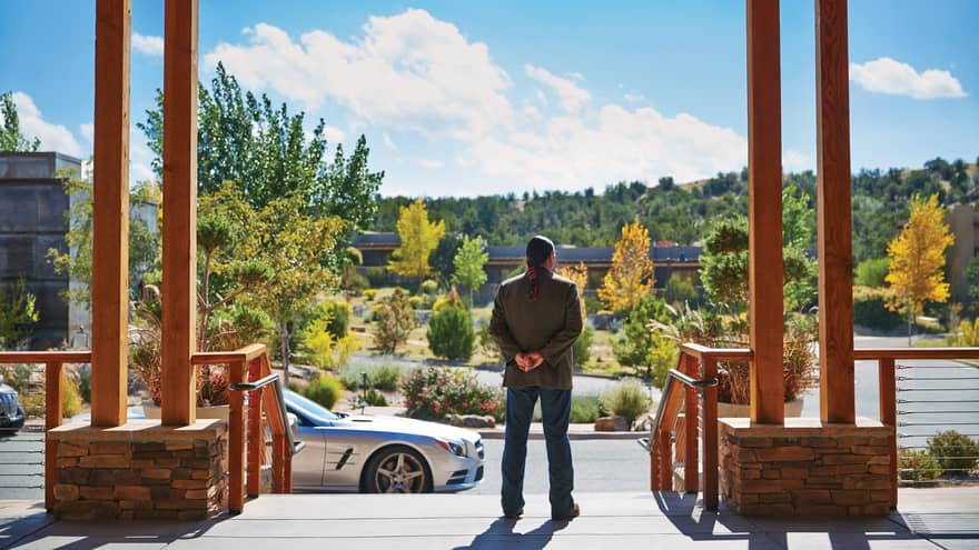 Back of man standing at top of Four Seasons Resort Santa Fe entrance, driveway