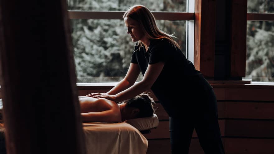 A woman receicing a massage in a dimly lit room.