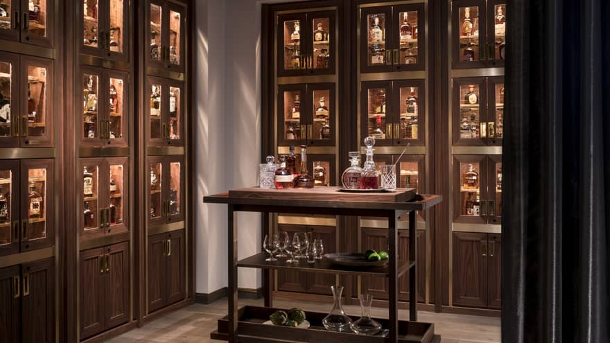 Various whiskey, bourbon, crystal bottles on bar