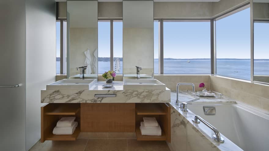 Bathroom with marble double vanity, sunken tub and wrap-around wall of windows