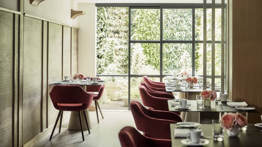 Biblioteca red retro-style velvet dining chairs at table, sunny room with floor-to-ceiling window