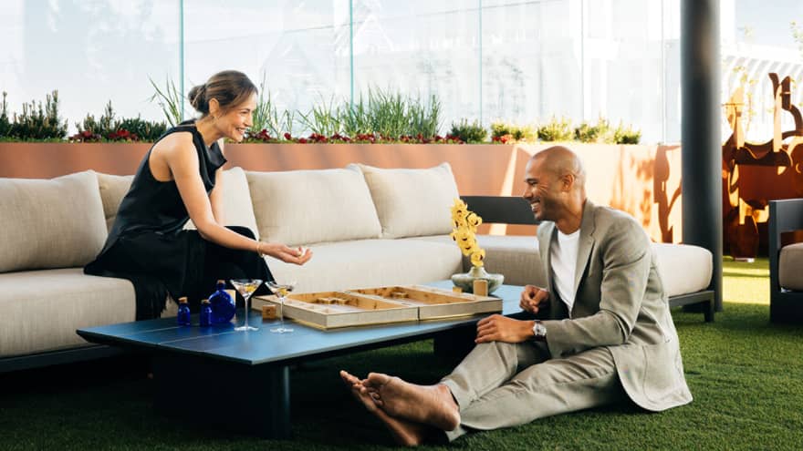 Man and woman enjoying snacks around a table on a rooftop terrace