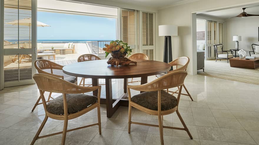 Residence dining room with round wood table retro wicker seats, sliding balcony shutters