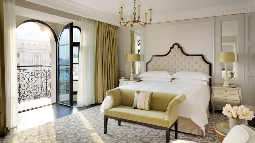 Honeymoon suite bed with chaise at foot, open balcony door