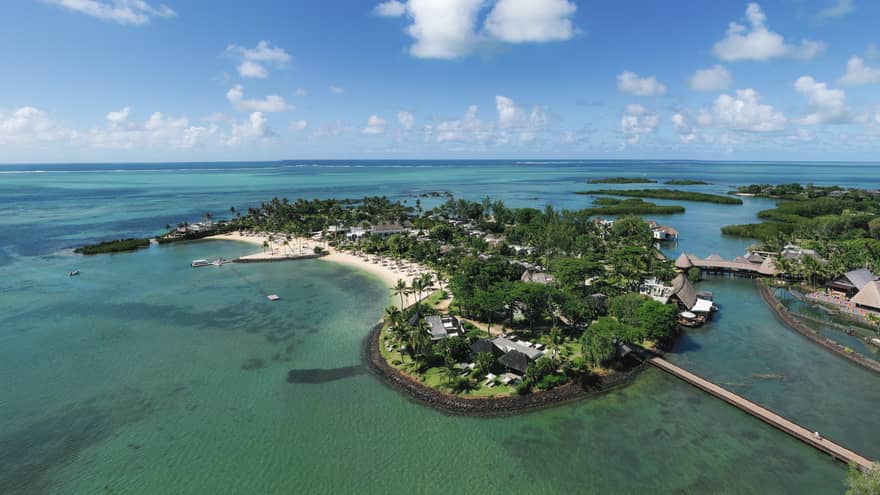 Aerial view of the lush island of Mauritius surrounded by blue-green waters and under blue skies