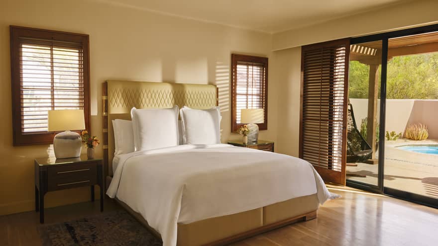 Sunlight streams into bedroom with wooden floors, king bed and walk-out terrace to a plunge pool
