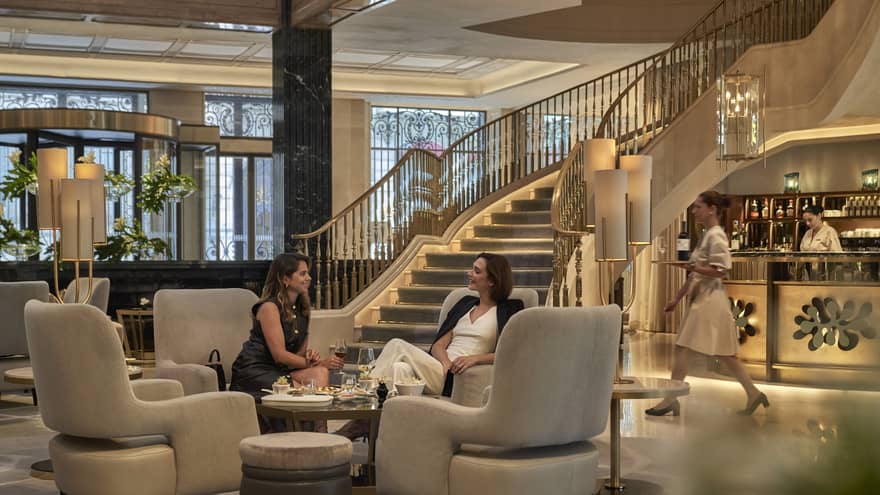 Two women having afternoon tea in main hall of the former Banco Español de Crédito, Madrid