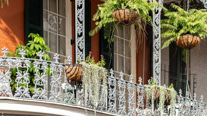 A balcony with plant pots hanging around it.