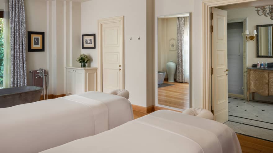 A light and spacious spa treatment room with two treatment tables side by side