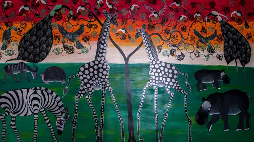 Colourful painted mural of giraffes, zebras, hippos, birds