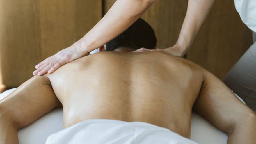 Man laying on massage table while getting a massage.