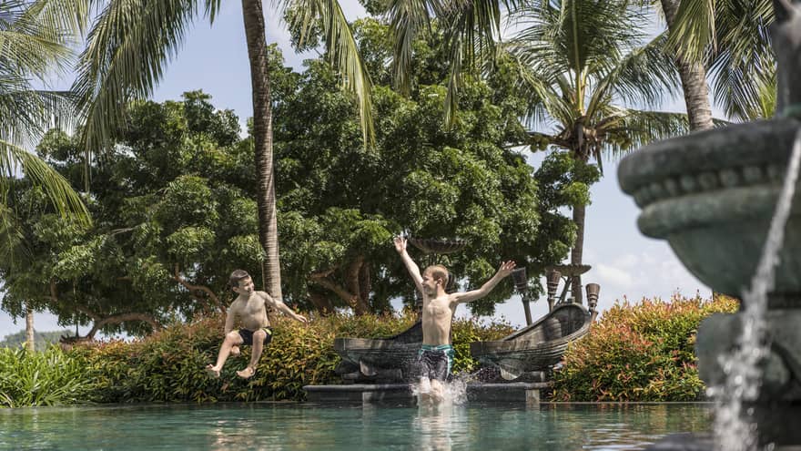 Two little boys jumping into the family pool at Four Seasons Langkawi