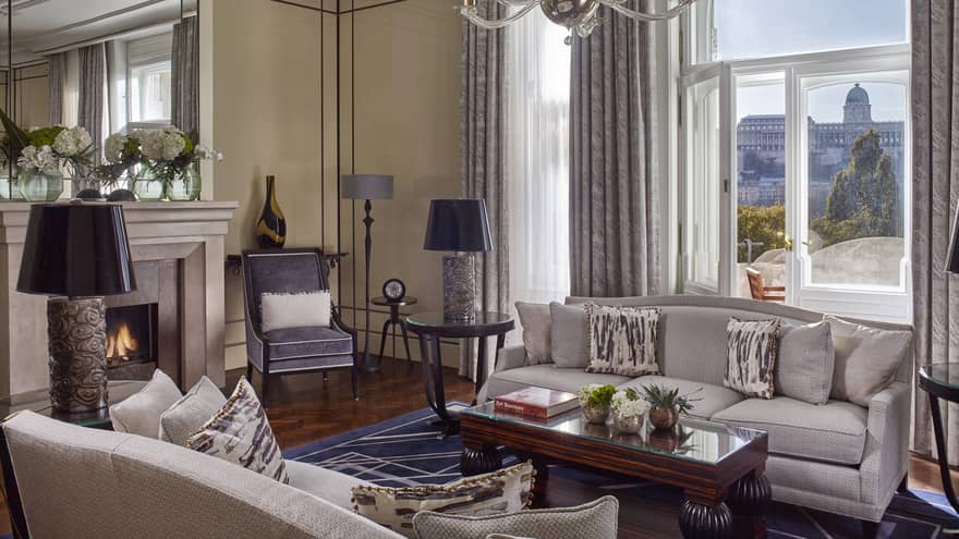 Royal Suite seating area with sofas, fireplace by large sunny window