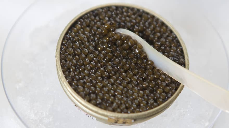 A container of fresh caviar served chilled over a bowl of ice