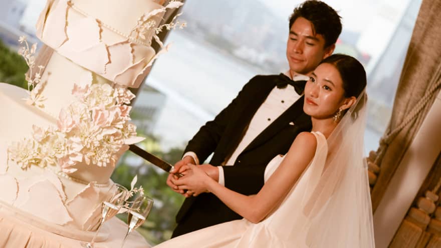 Bride and groom cut large wedding cake