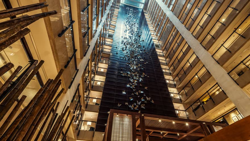 Looking up in 20-storey hotel atrium at 400 stainless-steel butterflies on column