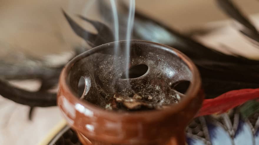 Incense burning in a small brown bowl.