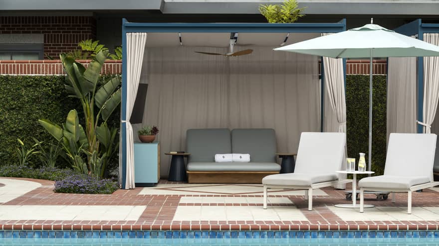 Lounge chairs and a cabana near an outdoor pool.