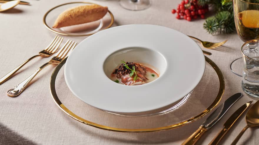 Elegant table setting with dish in round bowl in centre