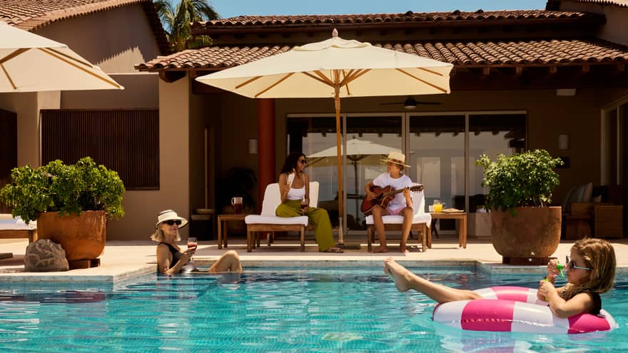 Kids in the pool and parents on deck chairs