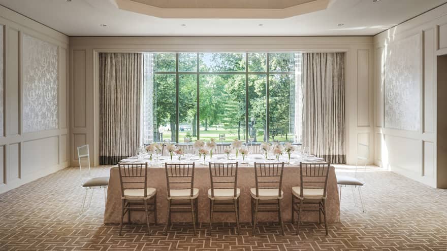 Private dining table with flowers under dome ceiling with crystal chandelier, by sunny window