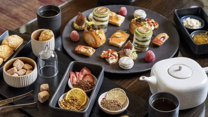 Various foods on a plate with a tea kettel.