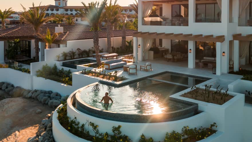 Luxury villa at a beachfront resort with a private infinity pool, ocean view and modern outdoor living spaces at sunset