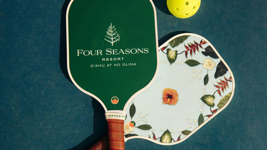 Pickleball paddles with Four Seasons Resort logo, and a yellow ball
